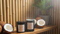 Two black jars with white labels on a wooden surface  with coconuts