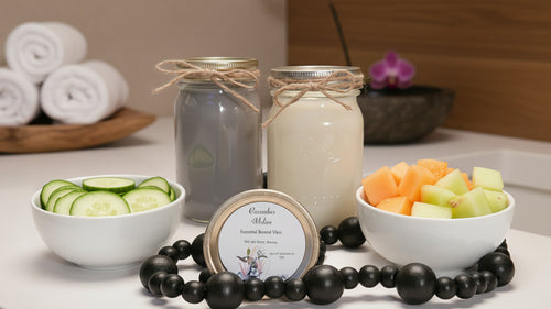 Two jars of smoothie, a bowl of fruit, and a bowl of cucumbers on a leopard print mat.