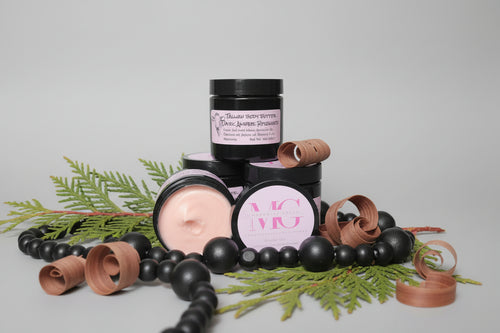 Jars of body butter with pine and shaved cedar