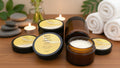 Collection of facial cleanser jars on a reflective surface with towels and candles
