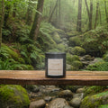 Jar of tallow sugar scrub on a wooden surface with a tree background