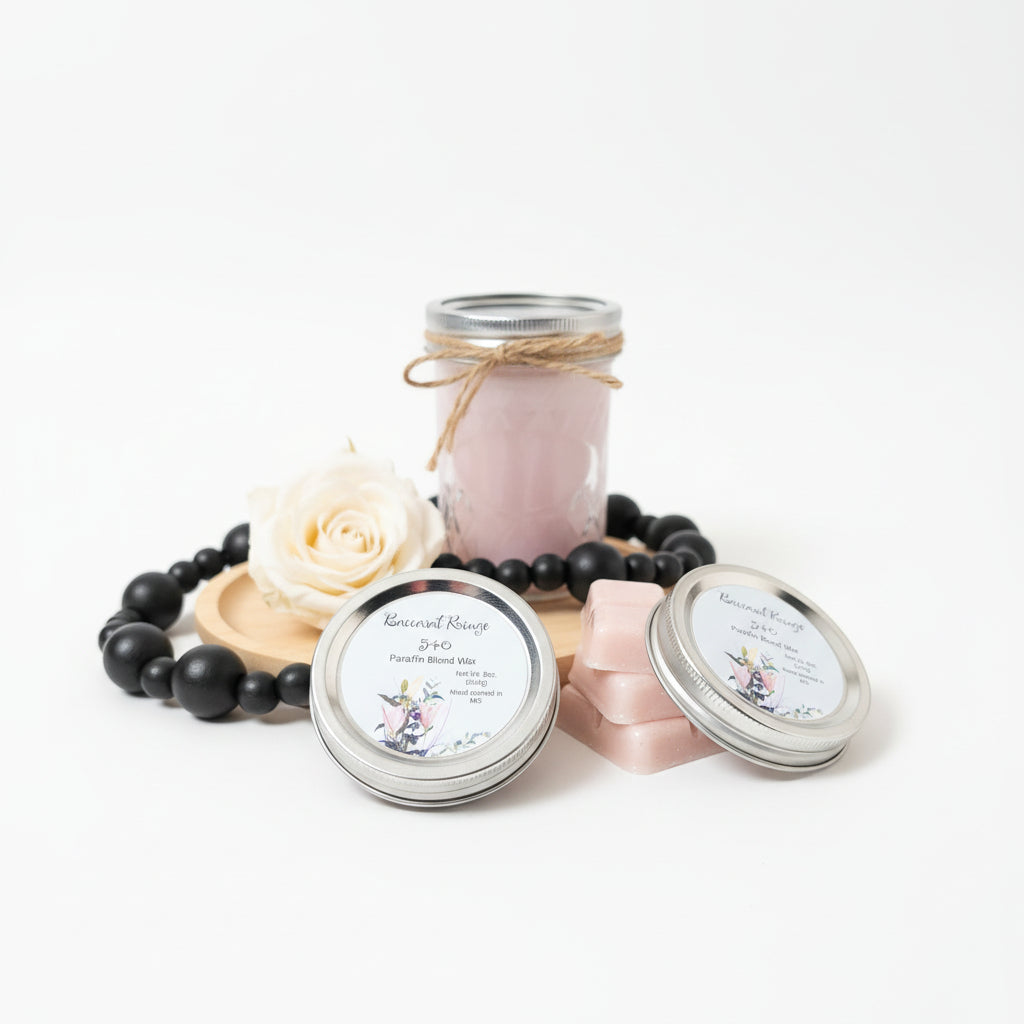 Candle jars with black beads, white rose, and pink ribbon on a white background